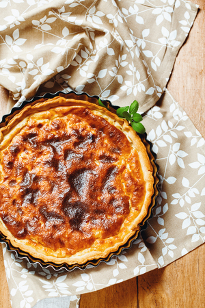 Pie or Tart Served with Fresh Herbs on Wooden Table. Rustic Style. Top View.の写真素材
