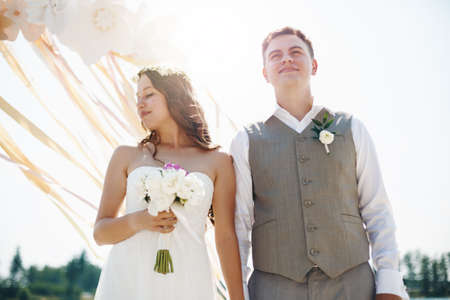 Emotional Moment of Wedding Ceremony. Beautiful Newlywed Couple. Groom and Bride Outdoors in Sun Light.の写真素材