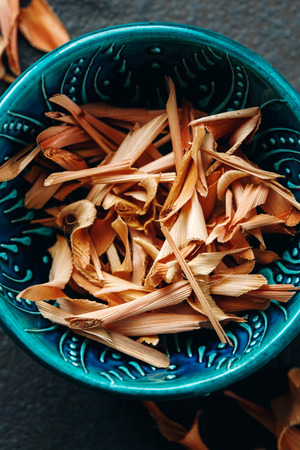 Close-up of Dried Lemongrass on Dark Stone Background in Authentic Blue Bowl. Selective Focus. Directly Above.の写真素材