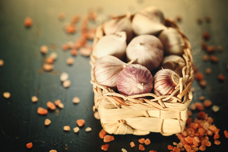 Garlic Close Up in a Basket with Pink Himalayan Salt on Dark Background. Image Toned. Selective Focus. Copy Space for Text.の写真素材