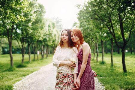 Two Young Pretty Girls Sisters or Friends Outdoors in Summer Time. Freedom Youth Concept. Happy Young Women. Selective Focus.の写真素材