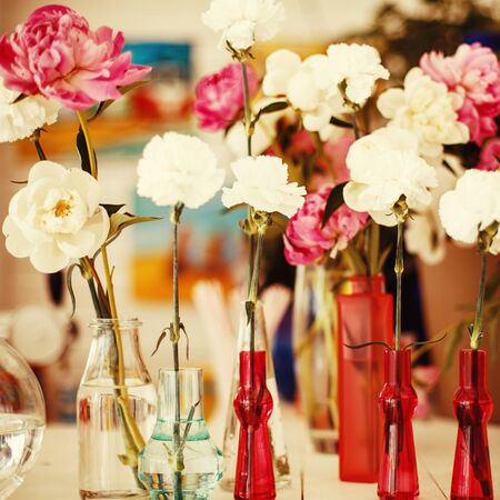 Different Flowers in different glass vases. Image toned with retro colors. Sekective focus.の写真素材