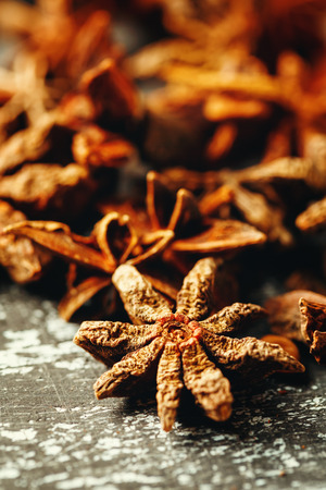 Food composition with heap of Star Anise on vintage black table. Selective focus.の写真素材