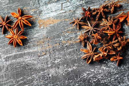 Food frame with heap of Star Anise on vintage black surface. View from above. Space for your text.の写真素材