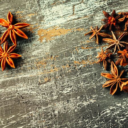 Food frame with heap of Star Anise on vintage black surface. View from above. Space for your text. Square composition.の写真素材