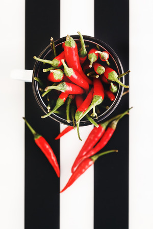 Red Chili Peppers in Mug on Black and White Background, Top Viewの写真素材