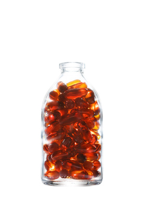 Bottle with gelatin capsules on white background. Fish oil, omega 3-6-9 dietary supplement.の写真素材