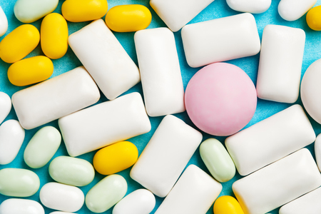 Close-up of assortment of chewing gums, mint candies and drops on bright blue backgroundの写真素材