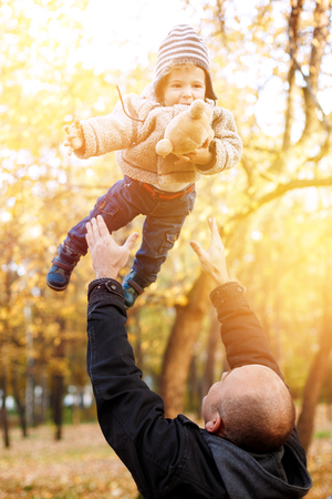 Father having fun with his little son at the nature. Toned, lens flare.の写真素材