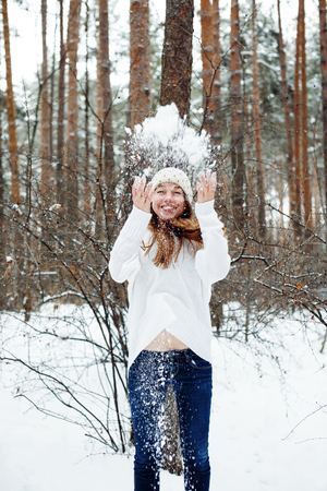 Young beautiful woman having fun in winter park. Christmas holidays, winter vacation concept.の写真素材