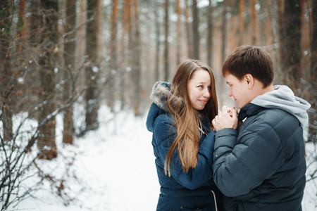 Couple in love having fun in winter holidays. Snow winter forest on the background.の写真素材