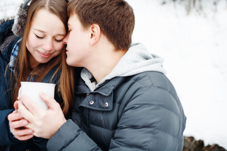 Young couple having fun outdoors in winter park, holding hands. Loving couple outdoors. Close-up, selective focus.の写真素材