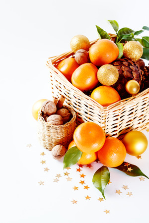 Christmas composition with tangerines, cones, walnut, and decorations over white background. Holiday greeting card.の写真素材