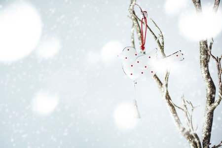 Christmas decoration with vintage bird on a silver branch. Retro Christmas concept, selective focus.の写真素材
