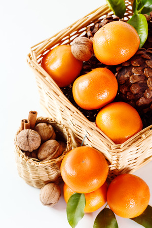 Christmas composition with tangerines, cones, walnut, and decorations over white background. Holiday greeting card.の写真素材