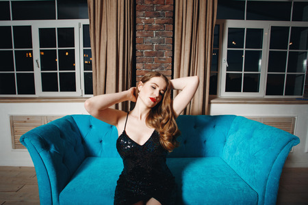 Seductive sexy model posing in loft interior in black dressの写真素材