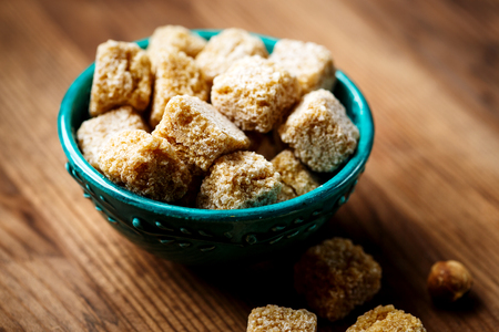 Brown sugar in a bowl on wooden background, selective focusの写真素材