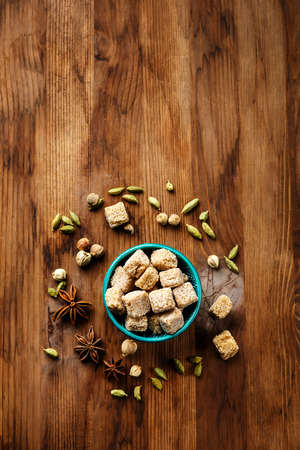 Brown sugar and spices cardamom and anise stars on wooden background, top view, copy spaceの写真素材