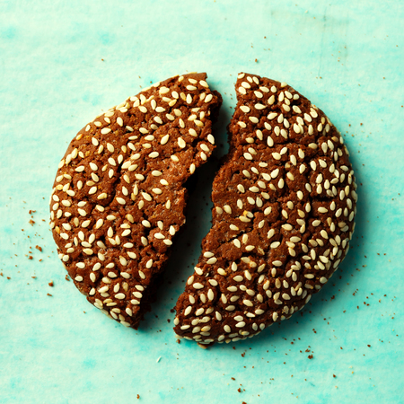 Close-up of cracked into two halves chocolate cookie with sesame, top viewの写真素材