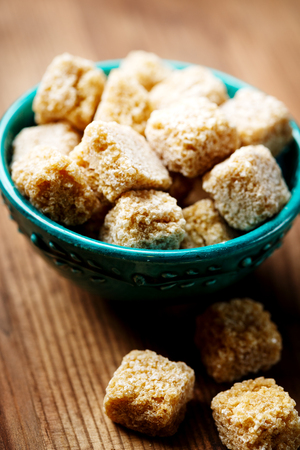 Brown sugar in a bowl on wooden background, selective focusの写真素材