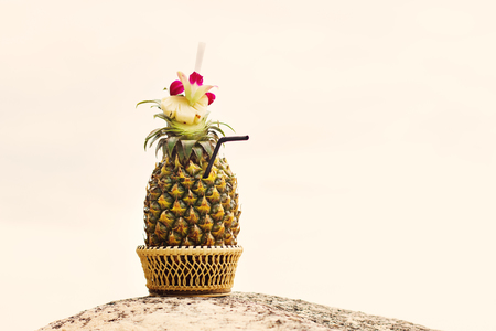 Exotic cocktail, pina colada in a pineapple in sunny dayの写真素材