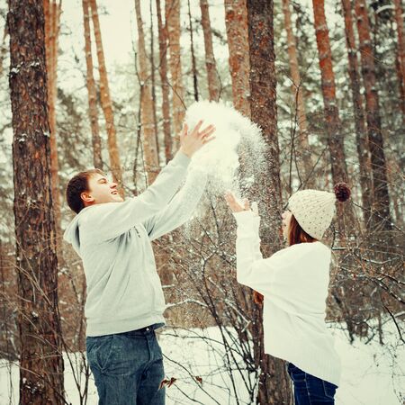 Young loving couple having fun in winter forest, winter vacation concept, tonedの写真素材