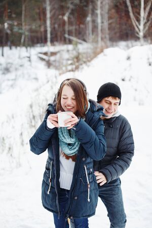 Funny couple having fun outdoors, winter forest at the backgroundの写真素材