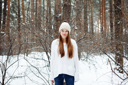 Funny young woman in cozy clothes having fun in winterの写真素材
