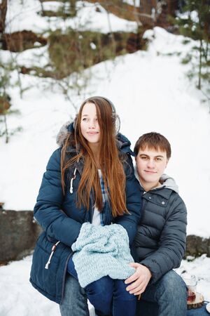 Loving couple having fun outdoors in winter rural weekend, woman sitting on man`s kneesの写真素材