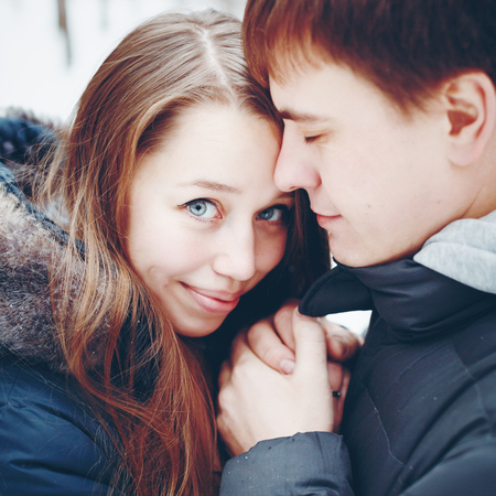Couple in love hugging and having fun in winter forest in holidays. Winter vacation. Headshot composition.の写真素材