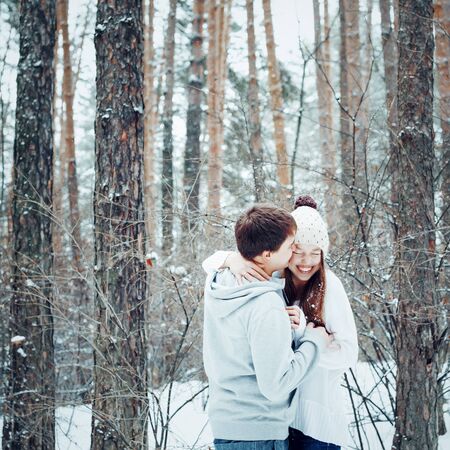 Young loving couple embracing and having fun in winter forest, winter vacation concept, tonedの写真素材