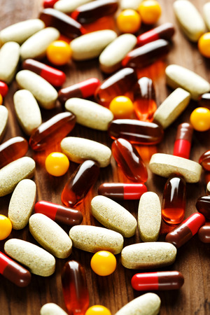 Organic dietary treatment, vitamin capsules on wooden background, selective focusの写真素材