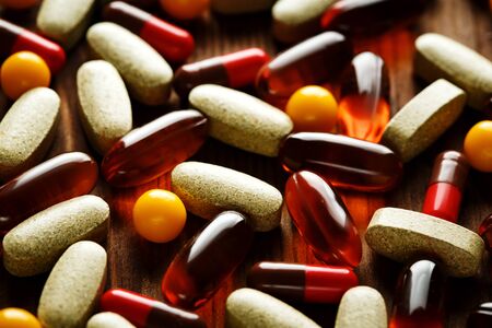 Organic dietary treatment, vitamin capsules on wooden background, selective focus, close-upの写真素材