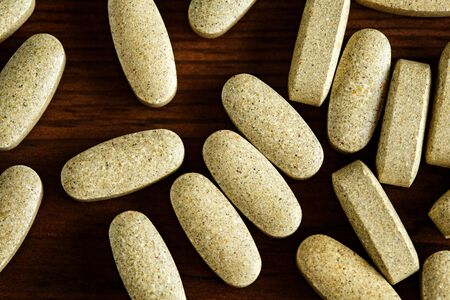 Organic dietary treatment, vitamin capsules on wooden background, flat lay, close-upの写真素材