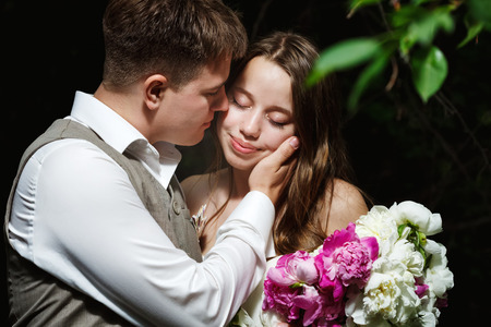 Loving wedding couple kissing in the park, close-upの写真素材