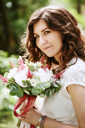 Young smiling bride with wedding flowers close-upの写真素材