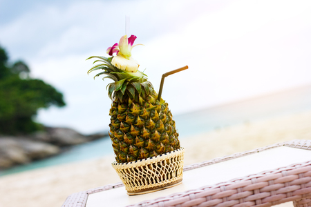 Exotic cocktail, pina colada in a pineapple at the beachの写真素材