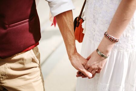 Young hipster couple holding hands, close-upの写真素材