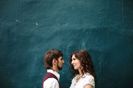 Loving couple looking at each other against blue shabby wall, copy spaceの写真素材