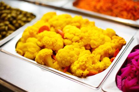 Cooked color yellow cauliflower in metallic dish. Street healthy food.の写真素材