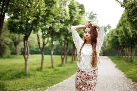 Young beautiful woman posing in the park alleyの写真素材
