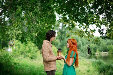 Young couple resting at the nature outdoors, couple holding hands and kissingの写真素材