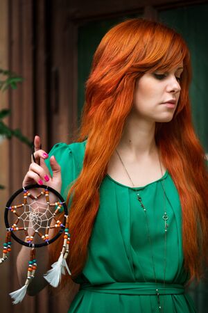 Young beautiful red hair woman posing in abandoned place, close-up portraitの写真素材