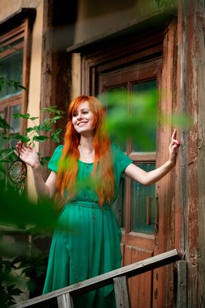 Young beautiful red hair woman smiling and posing in abandoned placeの写真素材