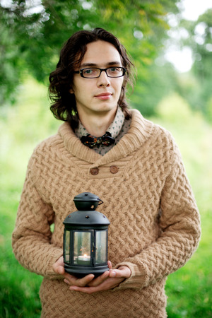 Young romantic multiracial man close-up portrait, man holding lanternの写真素材