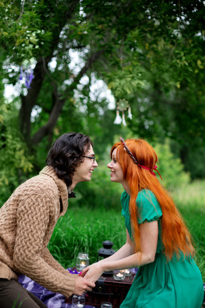 Young couple resting at the nature outdoors, picnic, couple holding hands and kissingの写真素材