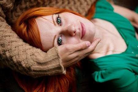 Close-up portrait of red hair woman with deep green eyes, love conceptの写真素材