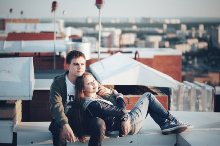 Romantic date on the roof. Loving couple dating on the roof at the sunset.の写真素材