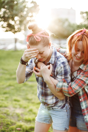Best friends concept, two young female in casual pin-up style, laughing and enjoying summertimeの写真素材
