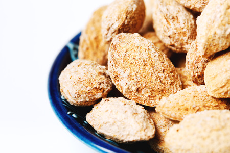 Roasted salted almond nuts in nutshell close-up on white backgroundの写真素材